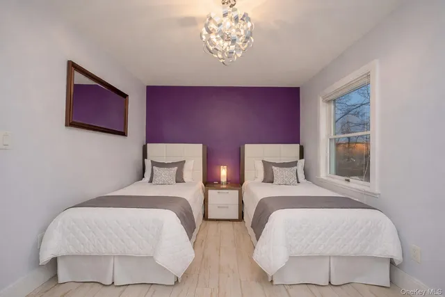 a bedroom with two beds and a chandelier