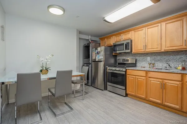 a kitchen with stainless steel appliances granite countertop a stove a sink a microwave and a refrigerator