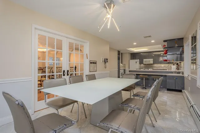 a dining room with stainless steel appliances kitchen island granite countertop a dining table chairs and granite counter tops