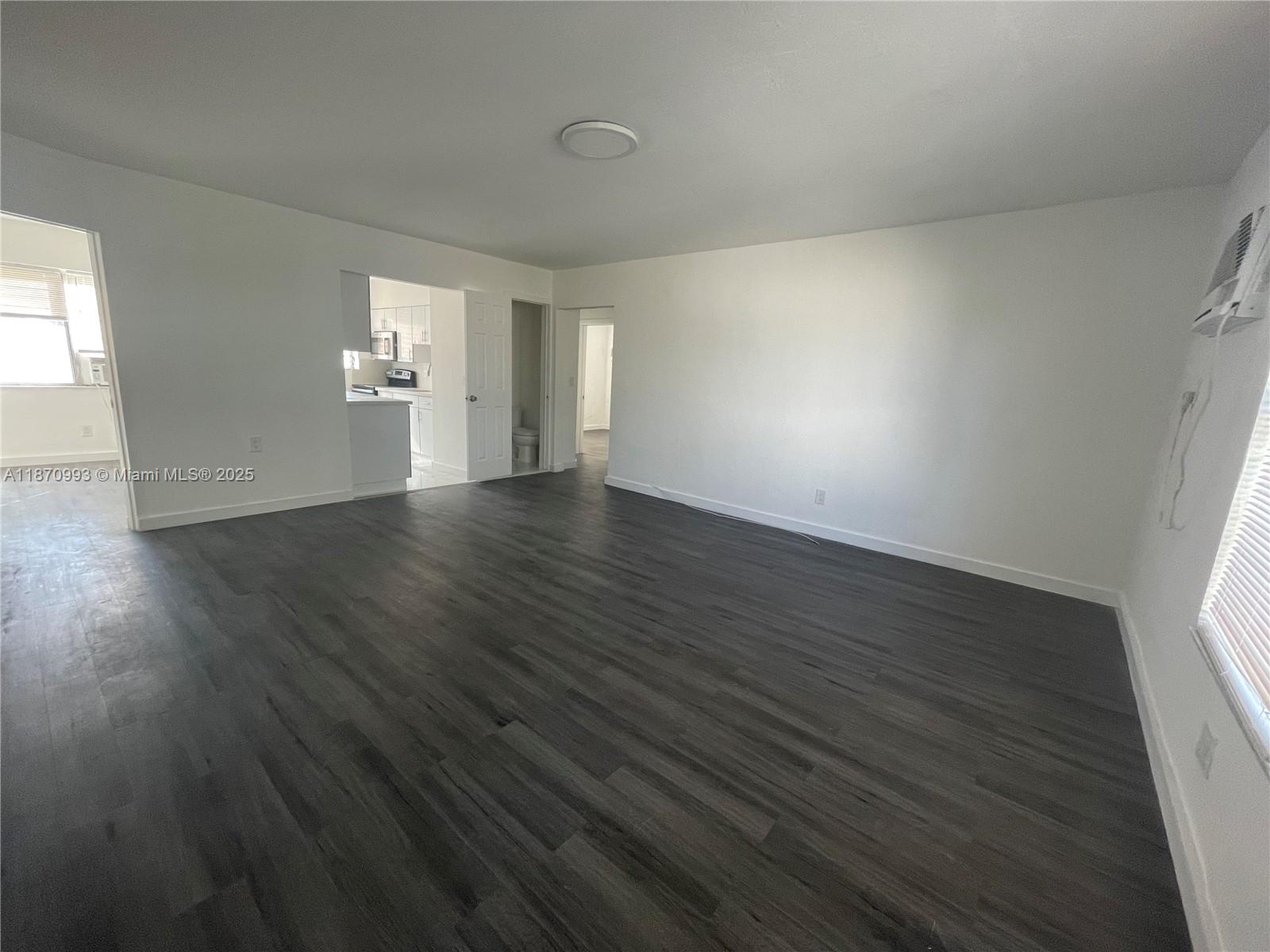 785 81st Street, Unit 3 Miami Beach, FL 33141 - Photo 2 of 12 a view of an empty room with wooden floor and windows