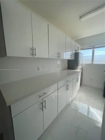 a kitchen with white cabinets and white appliances
