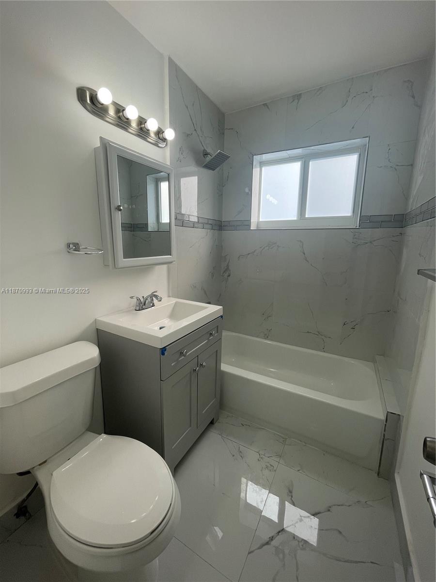 785 81st Street, Unit 3 Miami Beach, FL 33141 - Photo 7 of 12 a bathroom with a sink a toilet and bathtub