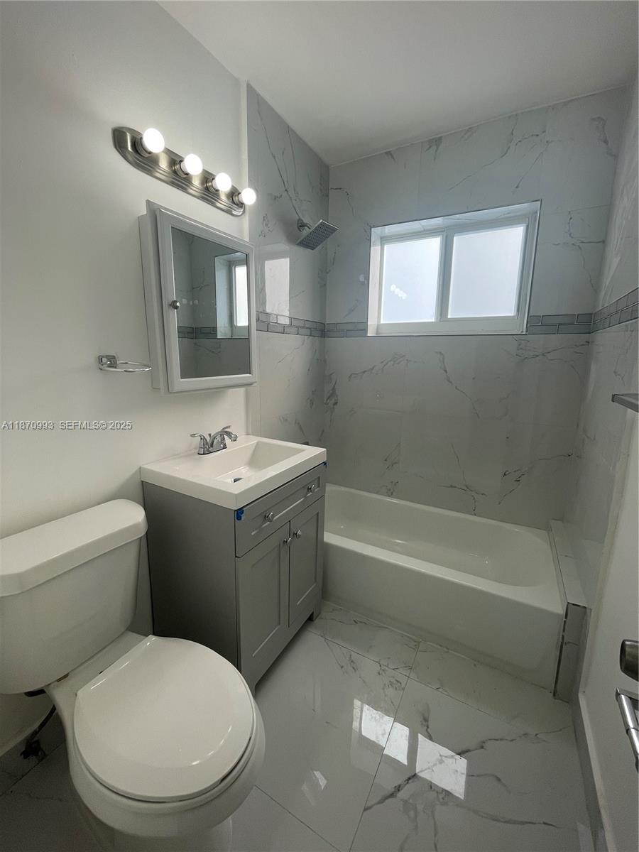 785 81st Street, Unit 3 Miami Beach, FL 33141 - Photo 7 of 12 a bathroom with a sink a toilet and shower