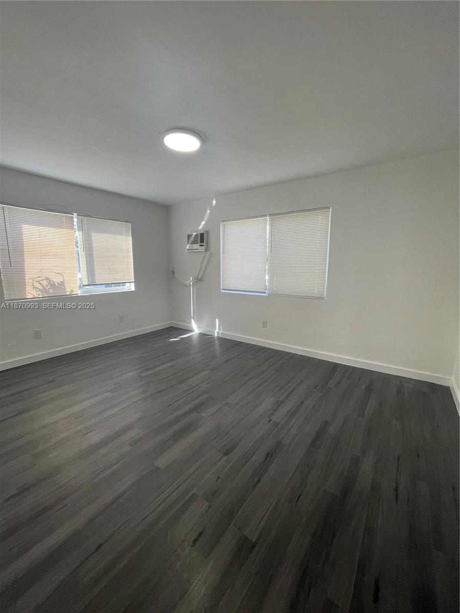 785 81st Street, Unit 3 Miami Beach, FL 33141 - Photo 8 of 12 an empty room with wooden floor and windows