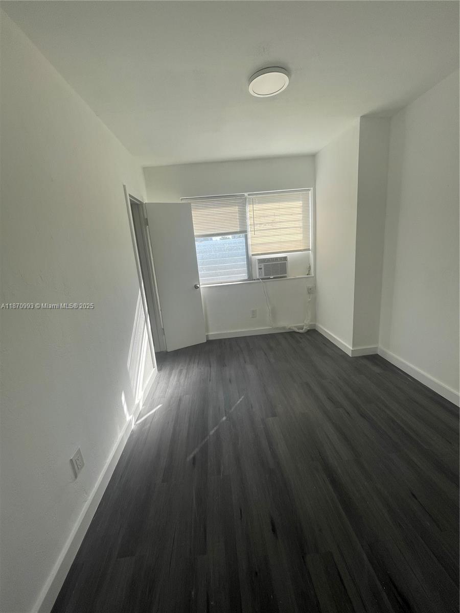 785 81st Street, Unit 3 Miami Beach, FL 33141 - Photo 10 of 12 wooden floor in an empty room with a window