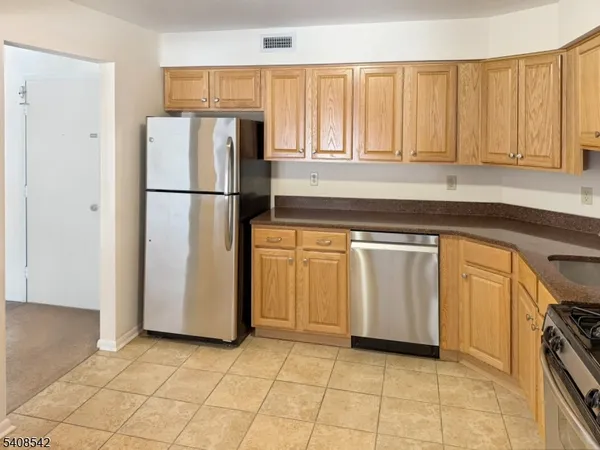 a kitchen with white cabinets and refrigerator
