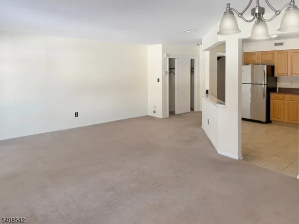 a view of empty room with a refrigerator