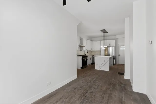 a view of a kitchen with refrigerator and cabinets