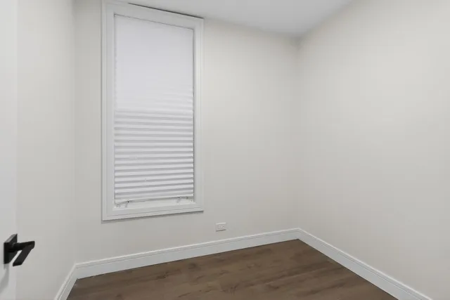 a view of a small space with wooden floor and a window