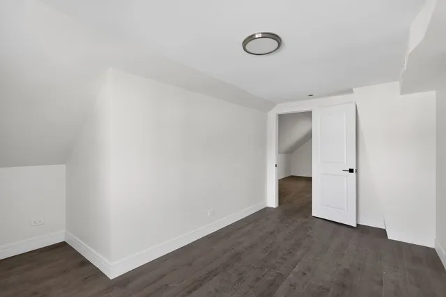 a view of an empty room with wooden floor and closet