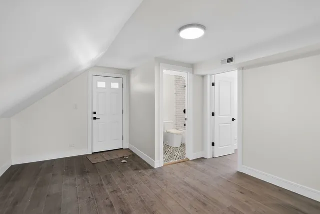 a view of empty room with wooden floor