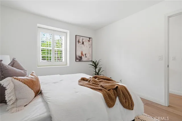 a large bed sitting in a bedroom next to a window