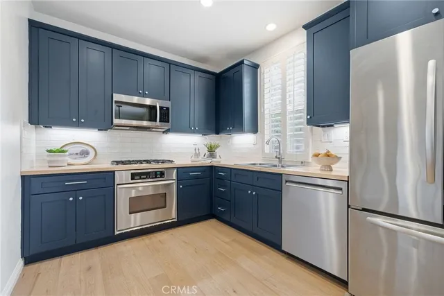 a kitchen with a refrigerator sink and wooden cabinets