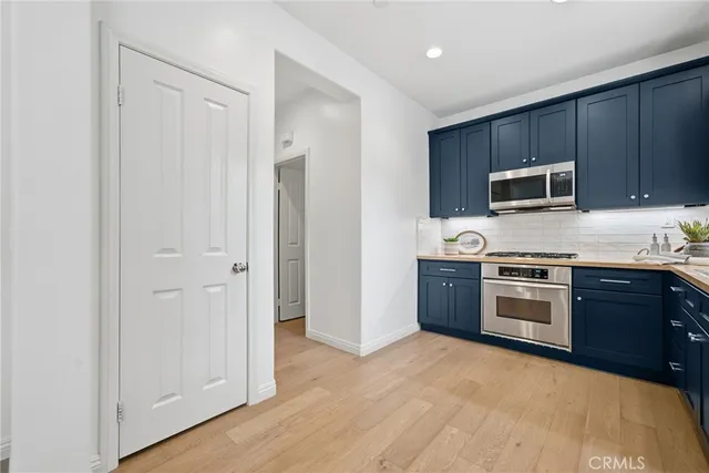 a view of a dining room and livingroom with furniture wooden floor a chandelier