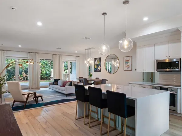 a open kitchen with cabinets a dining table and a large window