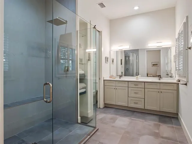 a bathroom with a shower sink and mirror