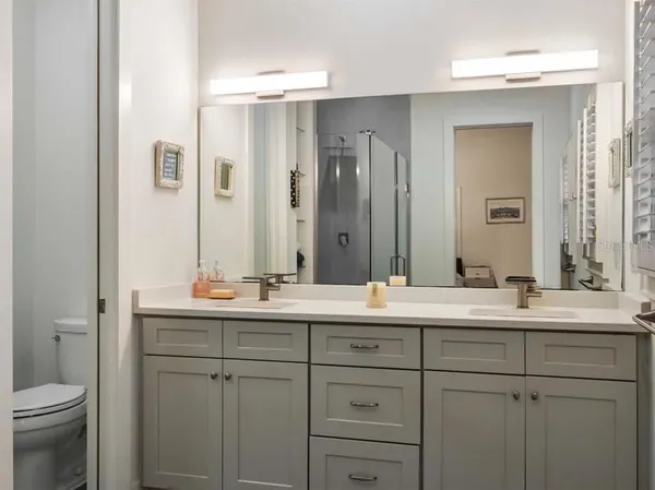 a bathroom with a double vanity sink mirror and toilet