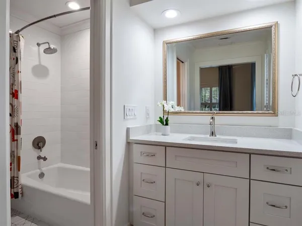 a bathroom with a tub sink and mirror