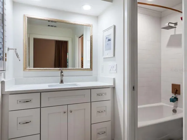 a bathroom with a tub sink and mirror