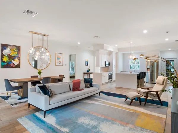 a living room with furniture a rug and white walls