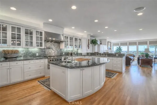 a kitchen with kitchen island granite countertop a stove and a sink