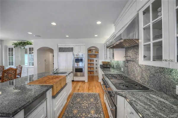 a large kitchen with kitchen island a large counter top space a stove and a wooden floor