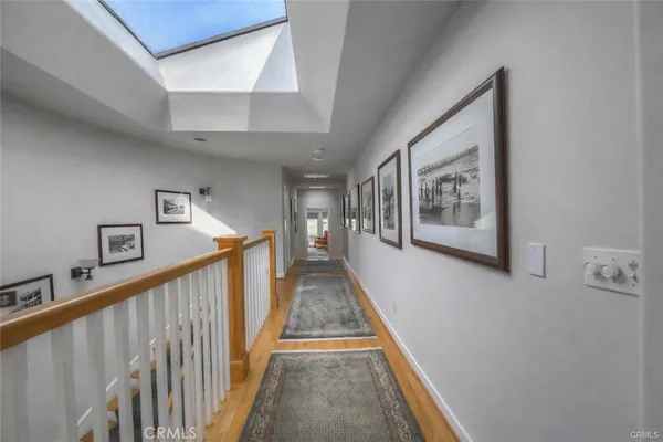 a view of a hallway with wooden floor and stairs