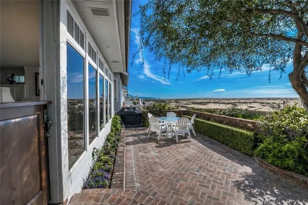 a view of a patio with lawn chairs next to a yard