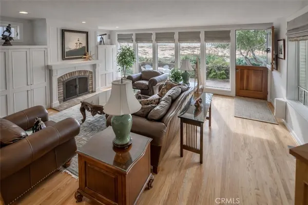 a living room with furniture a fireplace and a floor to ceiling window