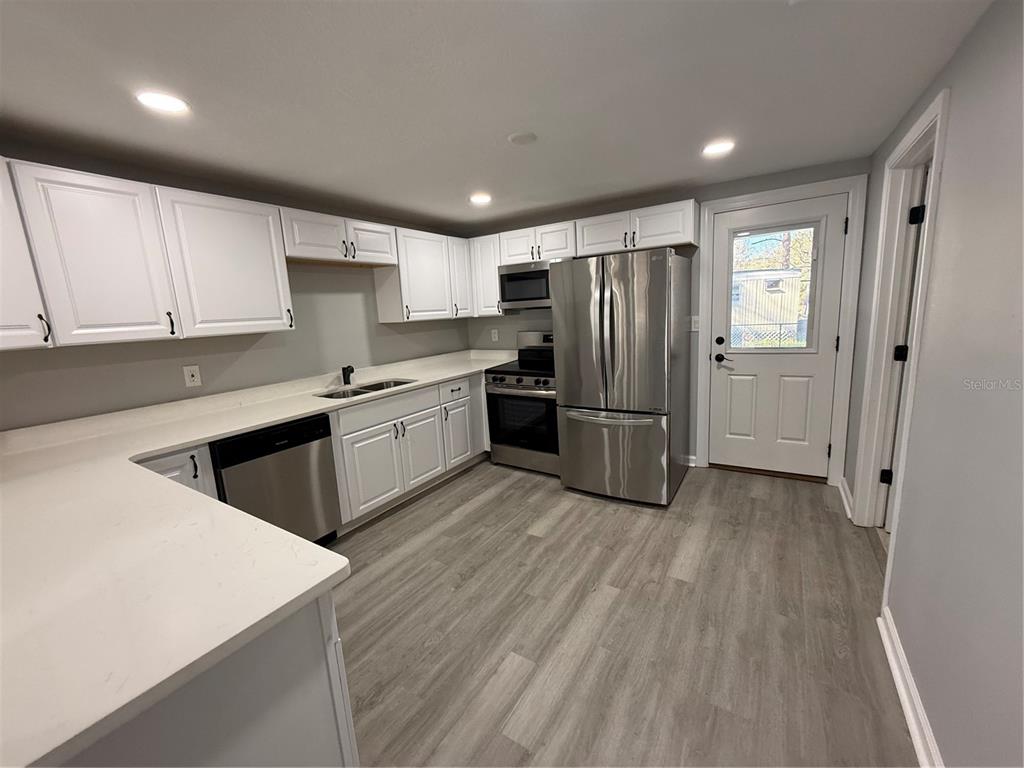 1205 Dell Street Starke, FL 32091 - Photo 3 of 12 a kitchen with stainless steel appliances a refrigerator sink and cabinets