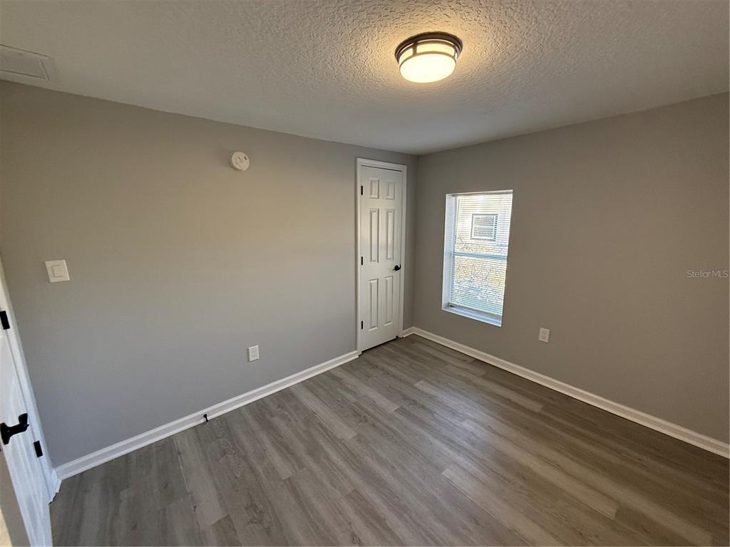 1205 Dell Street Starke, FL 32091 - Photo 4 of 12 an empty room with wooden floor and windows