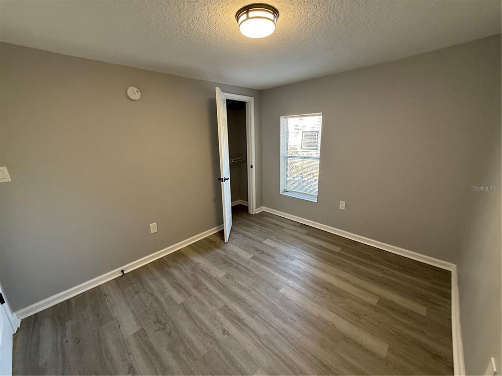 1205 Dell Street Starke, FL 32091 - Photo 8 of 12 an empty room with wooden floor and windows