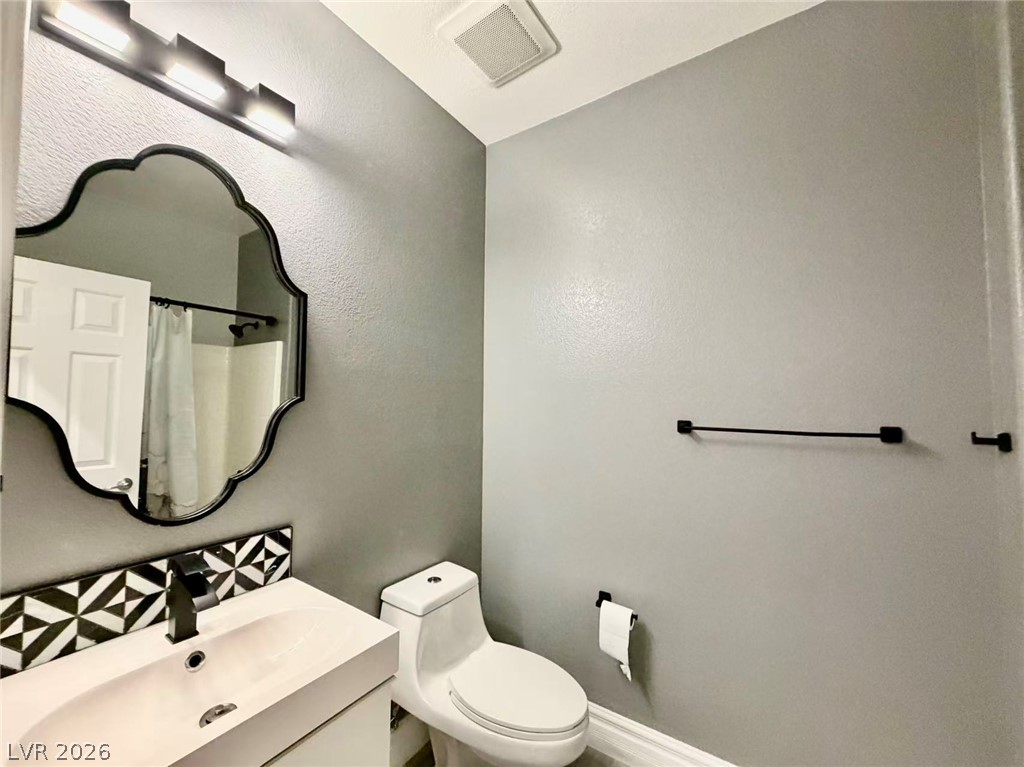 135 Tall Ruff Drive Las Vegas, NV 89148 - Photo 7 of 29 Refined bathroom with a decorative mirror, sleek vanity, and contemporary fixtures for everyday comfort.