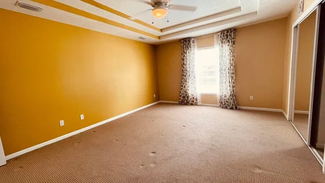 an empty room with a ceiling fan and a window