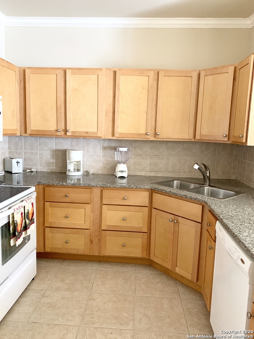 6160 Eckhert Road, Unit 505 San Antonio, TX 78240 - Photo 11 of 36 a kitchen with granite countertop white cabinets and white appliances