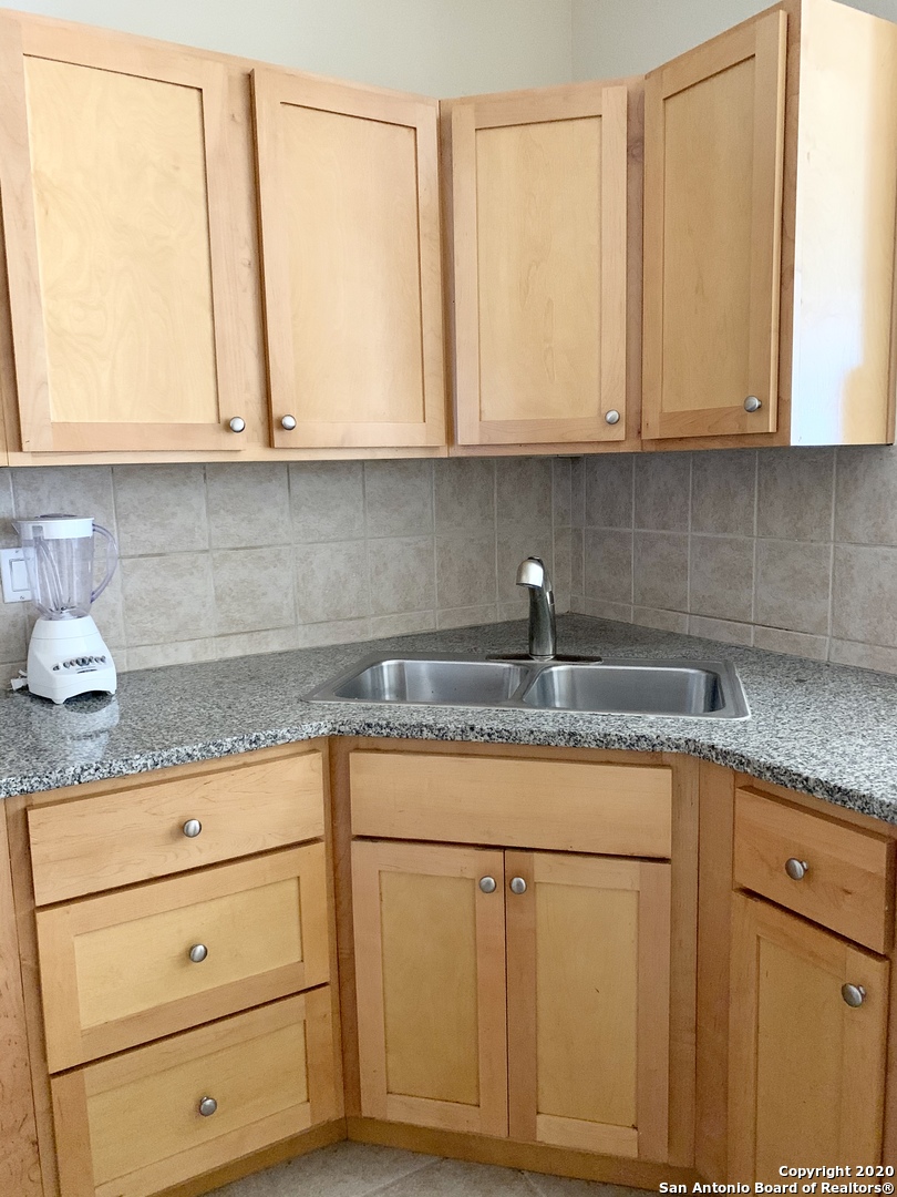 6160 Eckhert Road, Unit 505 San Antonio, TX 78240 - Photo 12 of 36 a kitchen with granite countertop white cabinets and white appliances