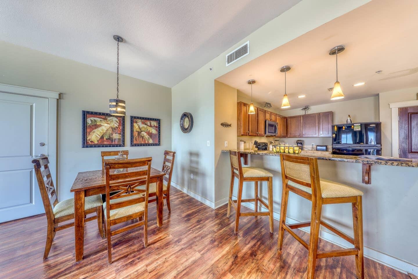 15100 Front Beach Road, Unit 1107 Panama City Beach, FL 32413 - Photo 11 of 24 a view of a dining room and livingroom with furniture wooden floor a chandelier
