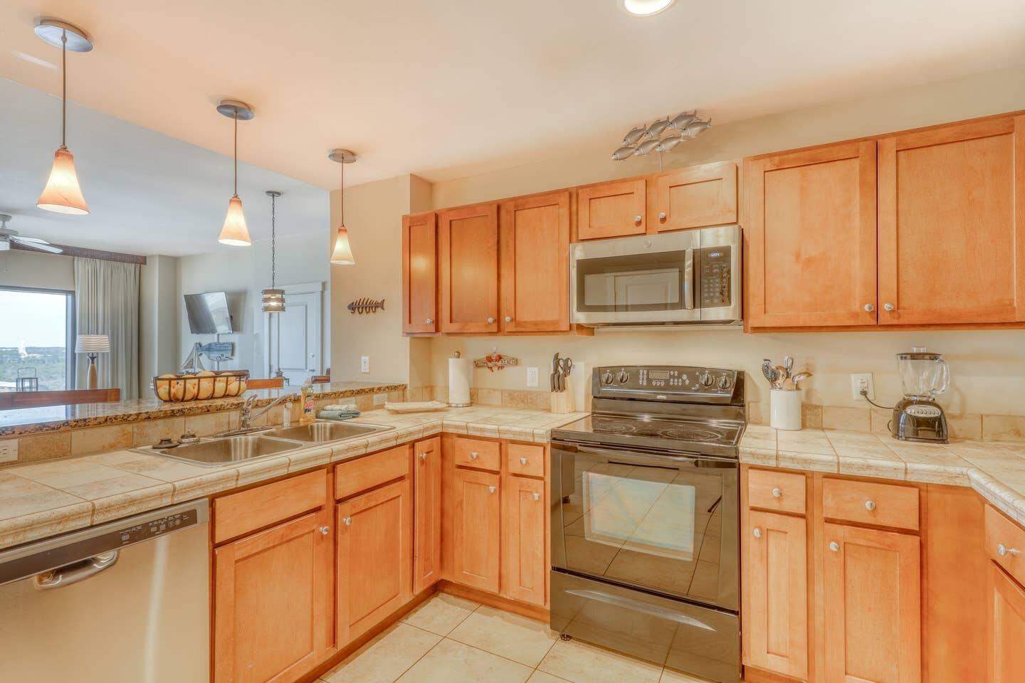 15100 Front Beach Road, Unit 1107 Panama City Beach, FL 32413 - Photo 12 of 24 a kitchen with stainless steel appliances granite countertop a sink stove and microwave