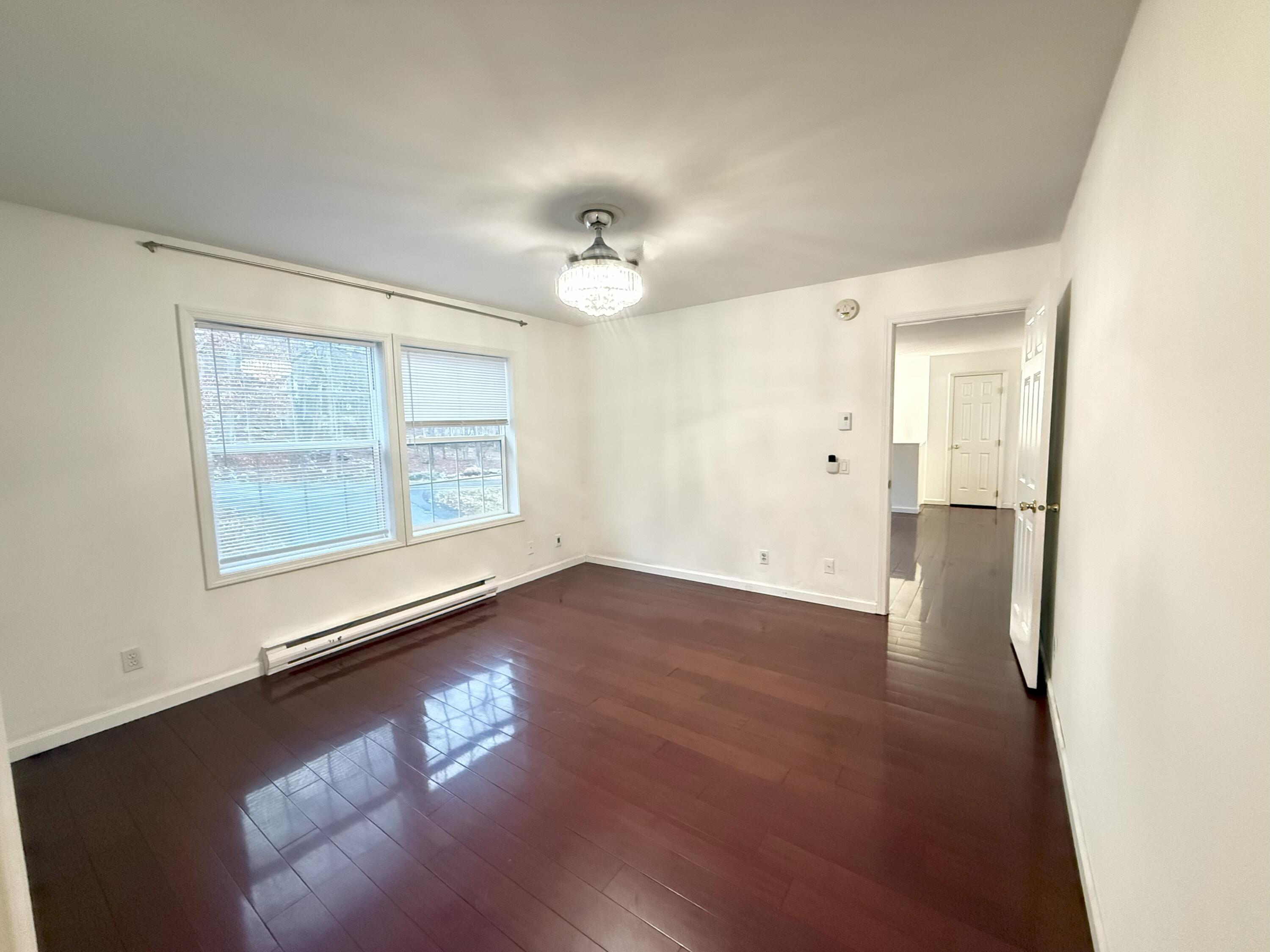 6486 Decker Road Bushkill, PA 18324 - Photo 13 of 53 an empty room with wooden floor chandelier and windows