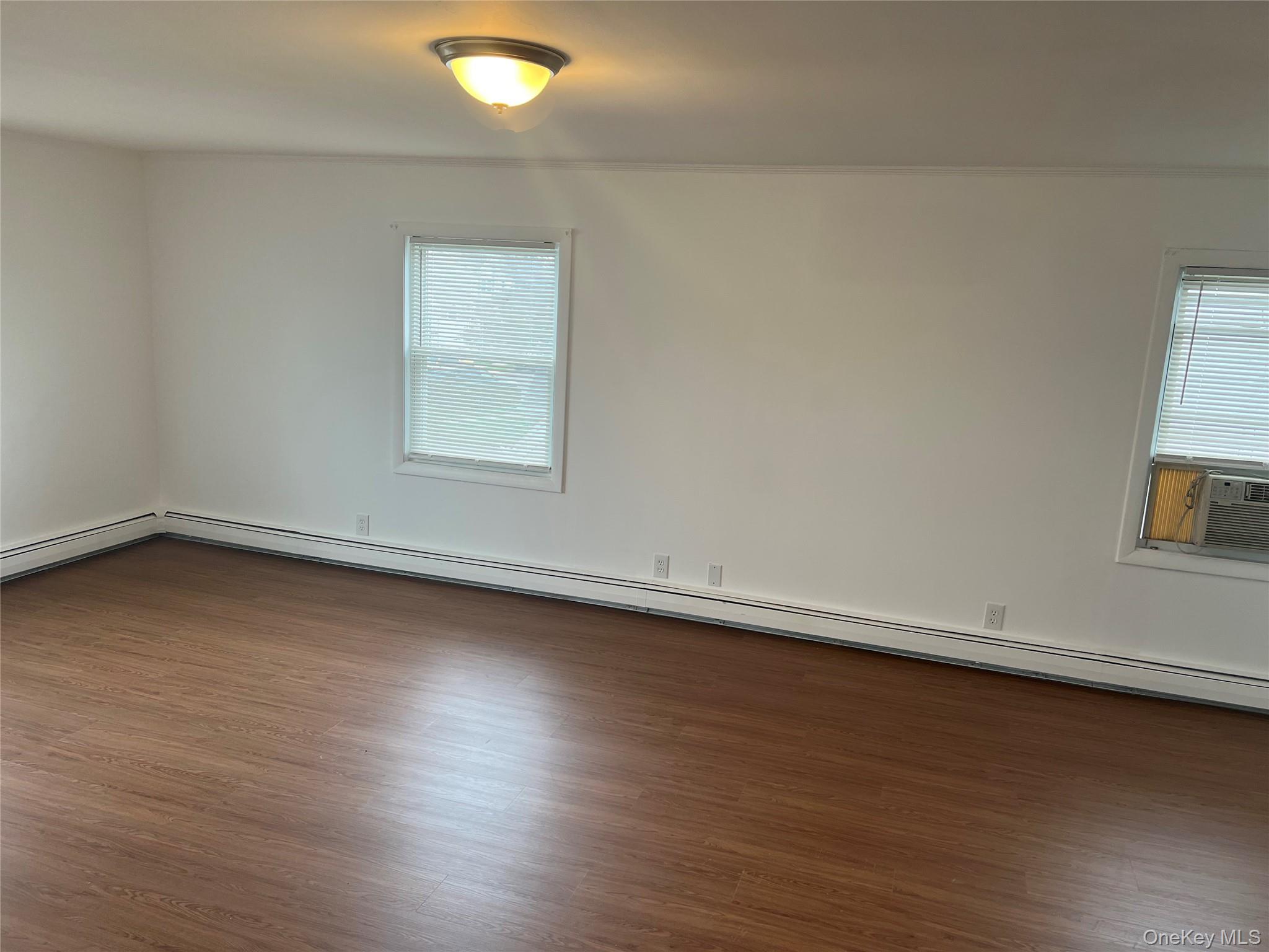 8 Gables Road Hicksville, NY 11801 - Photo 7 of 9 an empty room with wooden floor and windows