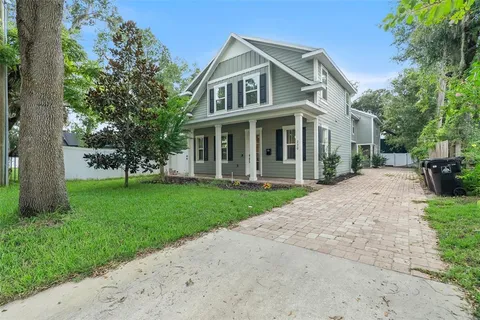 a front view of a house with a yard and trees
