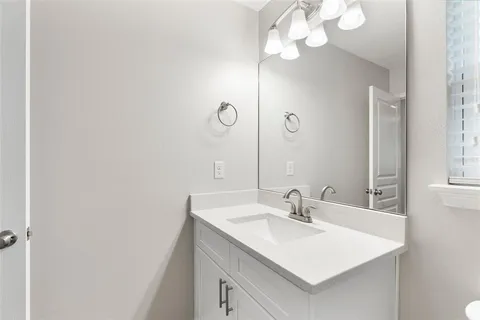 a bathroom with a sink vanity and a mirror