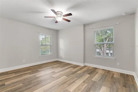 a view of an empty room with a window and wooden floor