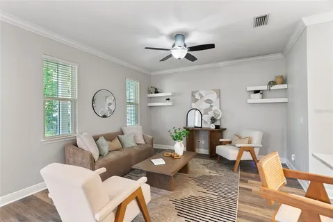 a living room with furniture a clock on wall and a window