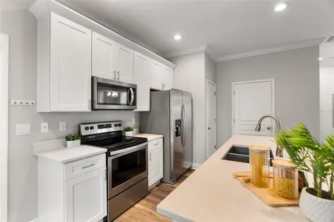 a kitchen with stainless steel appliances a stove a sink a microwave and cabinets
