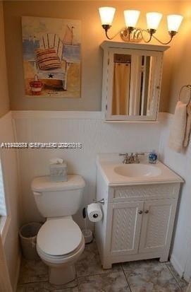 330 Coolidge Street, Unit 2 Hollywood, FL 33019 - Photo 4 of 7 a bathroom with a toilet a sink and a mirror