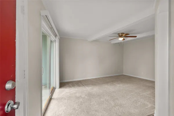 an empty room with a chandelier fan