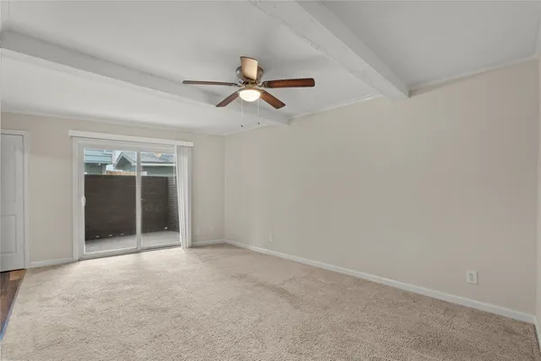 an empty room with a ceiling fan and window