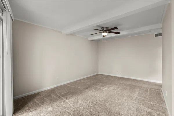 an empty room with a ceiling fan and a window