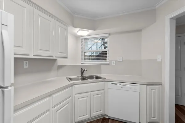 a kitchen with white cabinets and sink